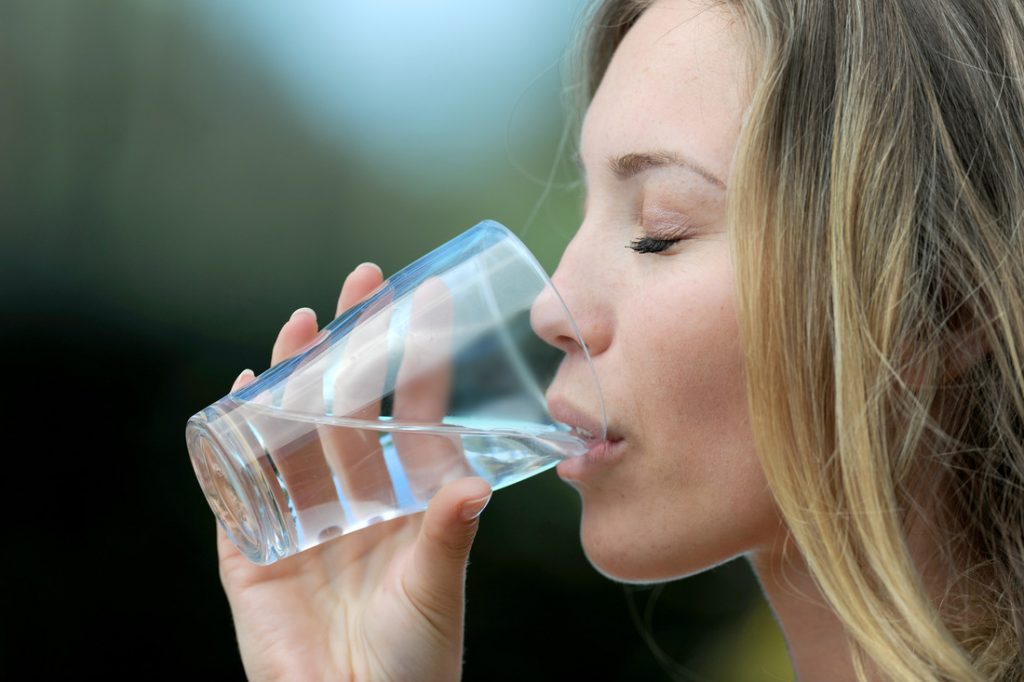 Closeup woman drinking water from glass