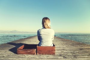 Relaxed woman sitting in her big suitcase 