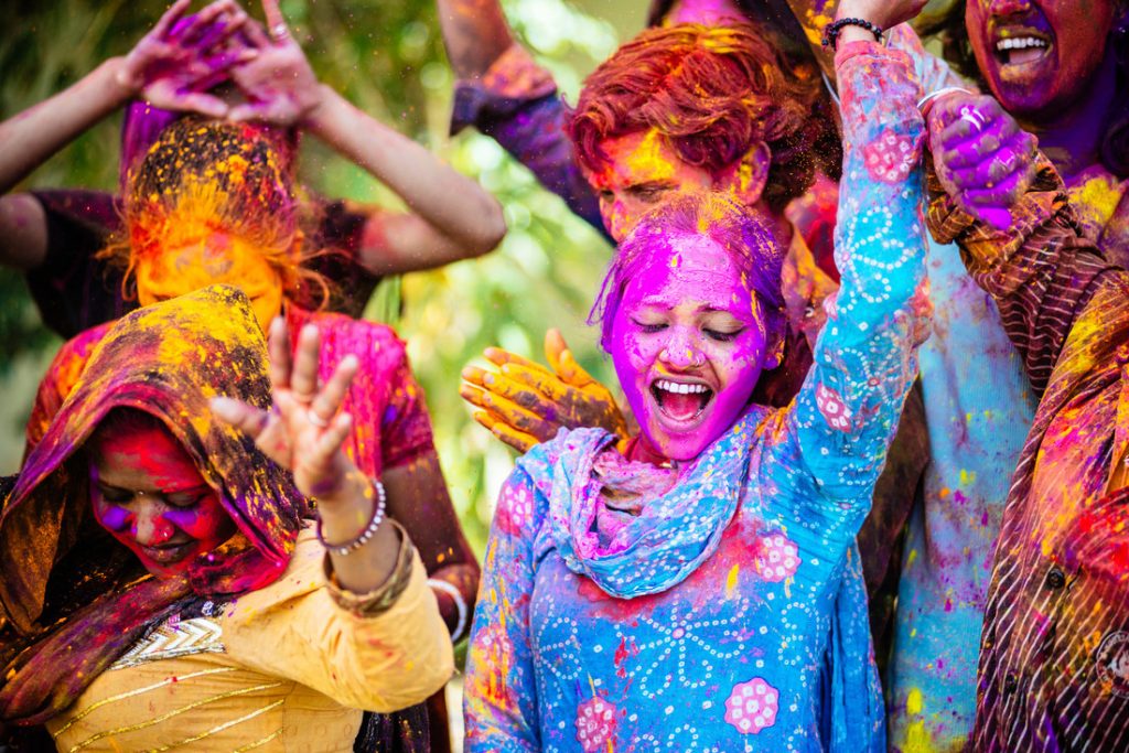 Indian Friends Dancing Covered on Holi colorful powder in India