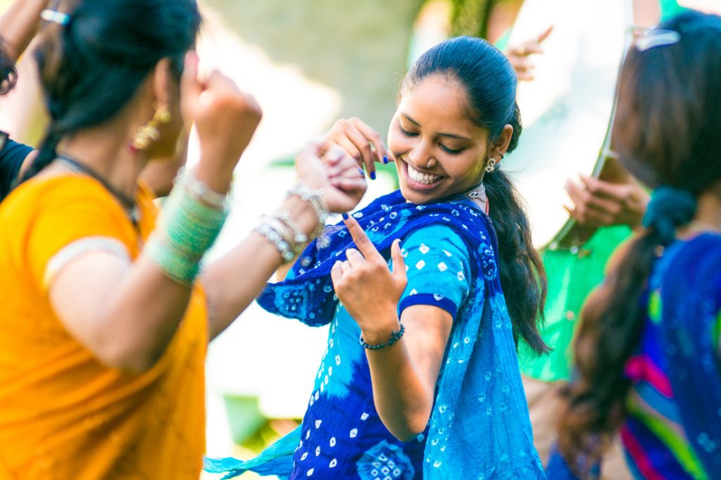 Young indian woman dancing with friends at holi