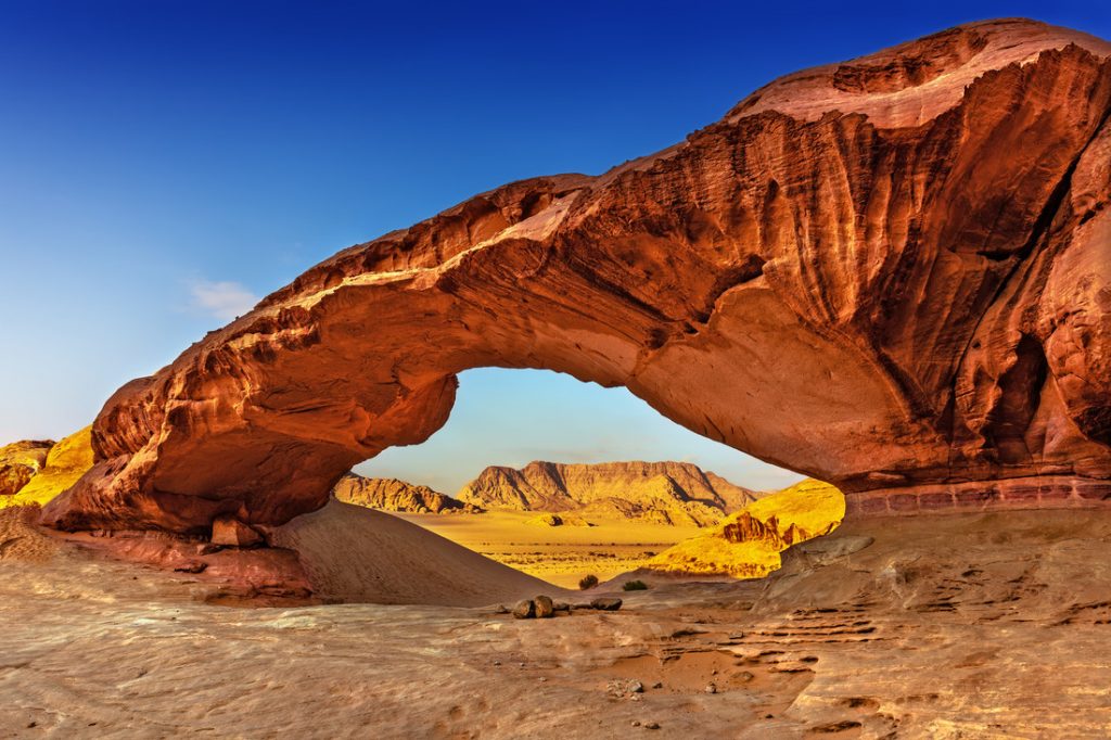 View through a rock arch in the desert of Wadi Rum, Jordan, Middle East. One of the best spring break destinations