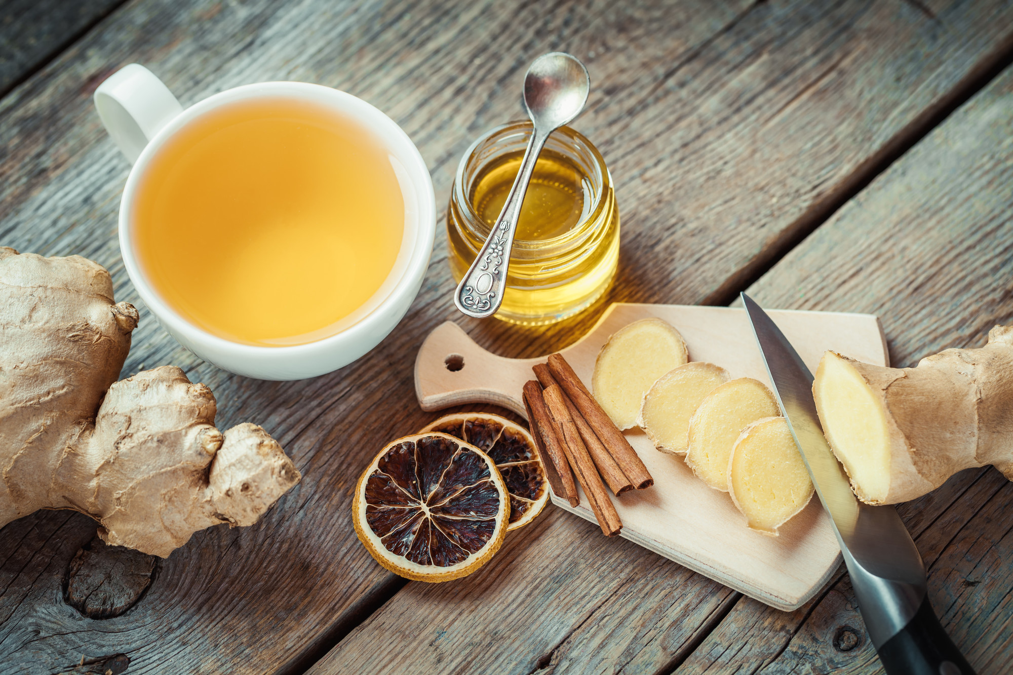 Ginger on cutting board, jar of honey, tea cup on kitchen table. Top view. spadreams kapha