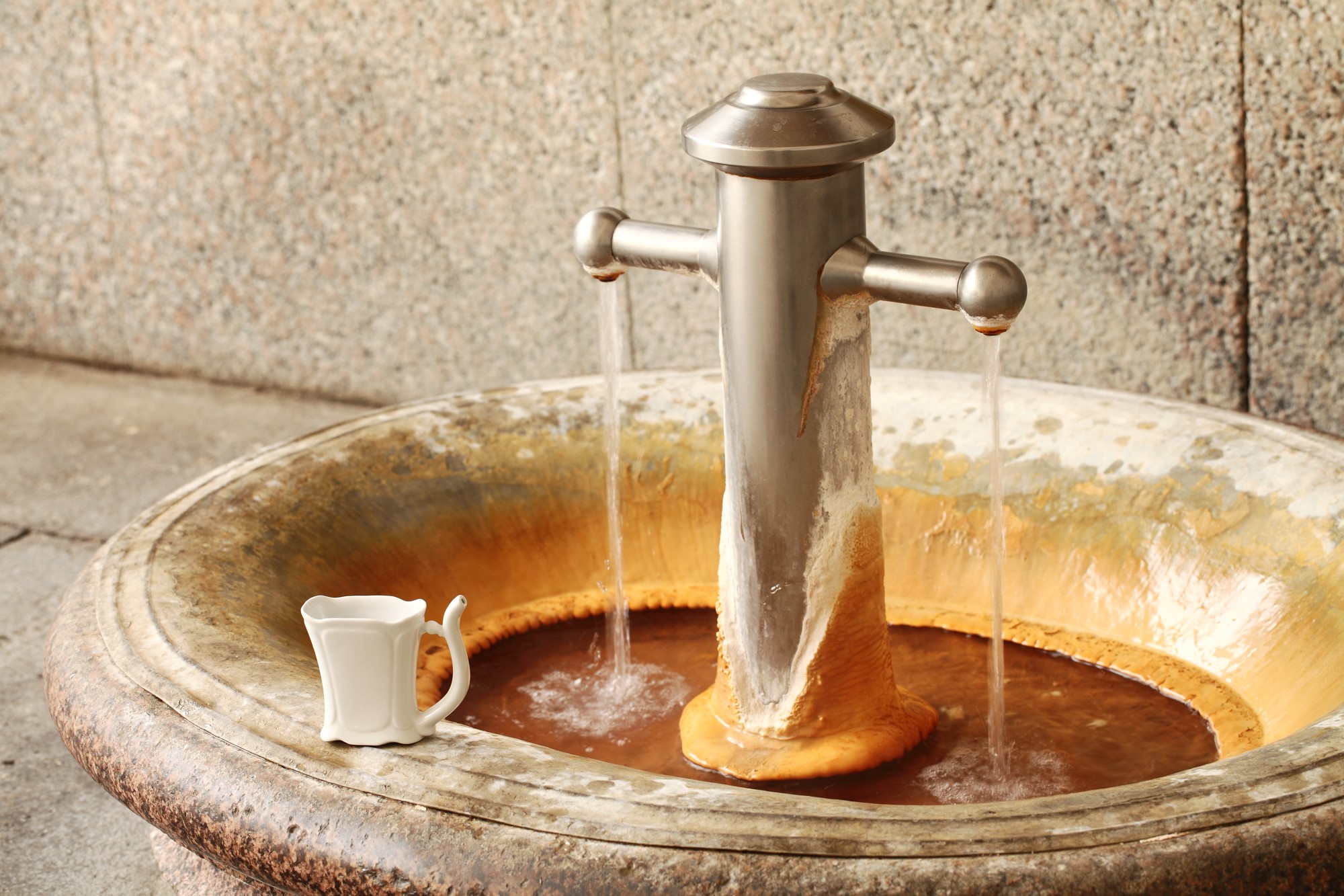 Hot mineral spring in Carlsbad (Karlovy Vary, Czech Republic) and porcelain mug.