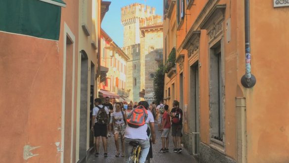 Man cycling through orange streets of sirmione.One of the best places to visit in Lake Garda. With SpaDreams