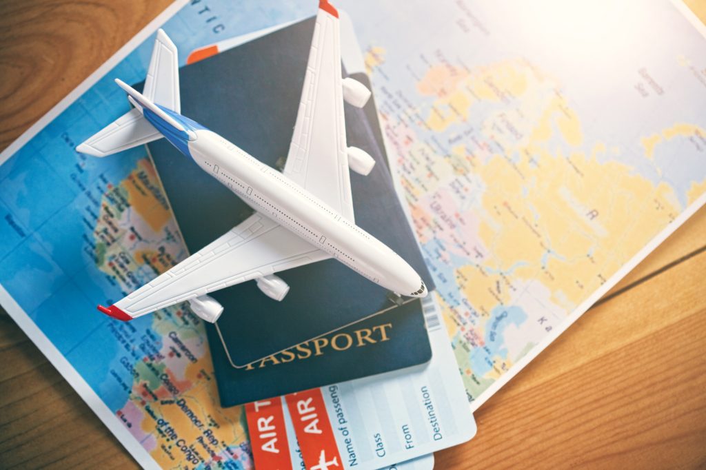 Model airplane, passports and airplane tickets on world map 