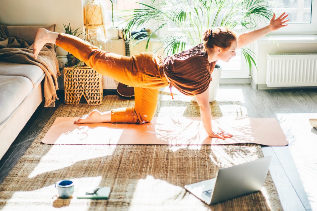 Young woman practising Yoga in her living room at home.